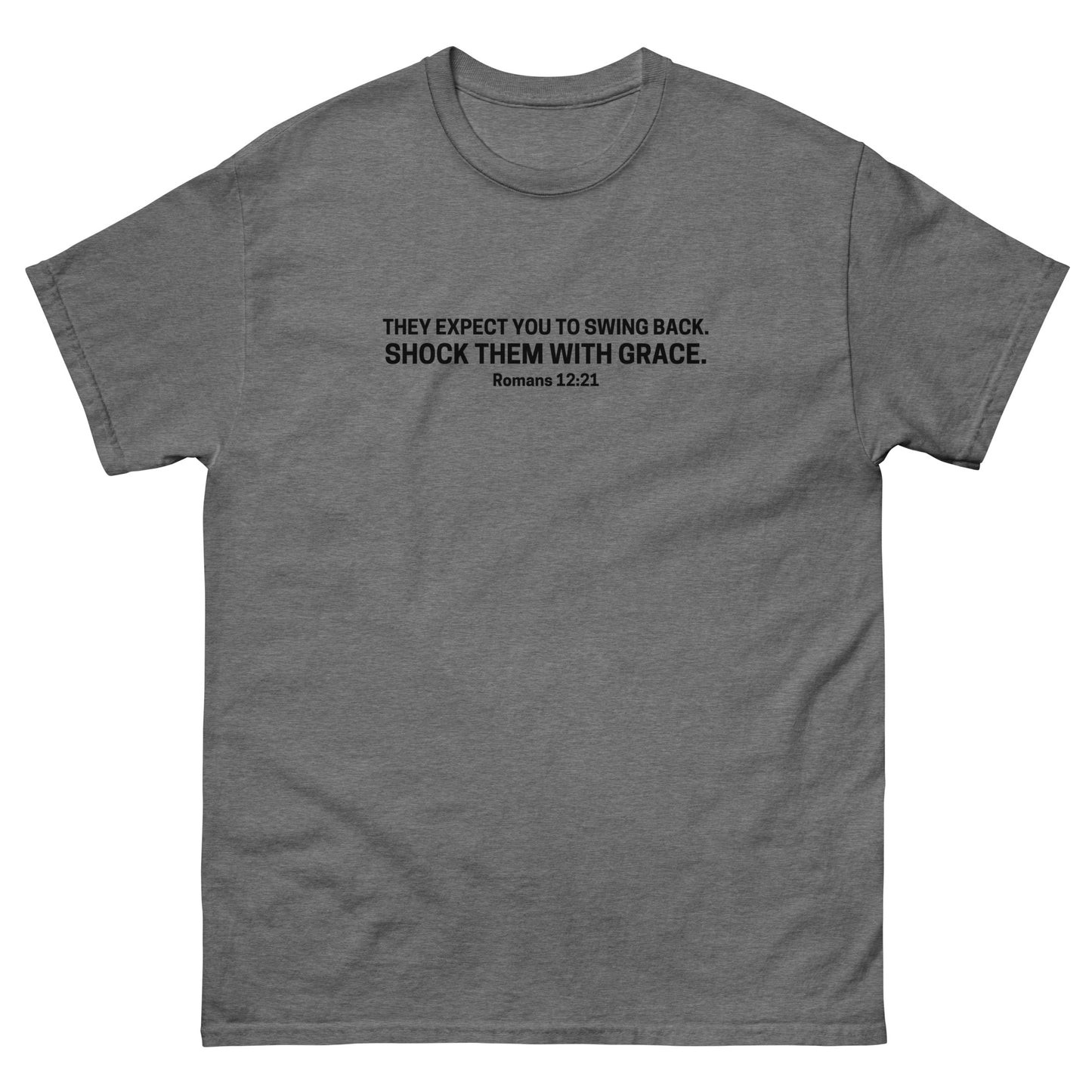 graphite heather gray t-shirt with black text on the front that reads 'They expect you to swing back. Shock them with grace. Romans 12:21,' displayed flat on a white background.