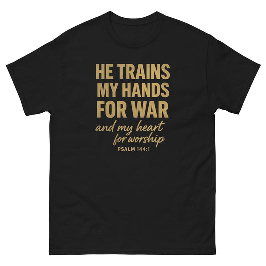 Front, Black t-shirt with bold gold text reading “He trains my hands for war and my heart for worship – Psalm 144:1,” Christian faith apparel.
