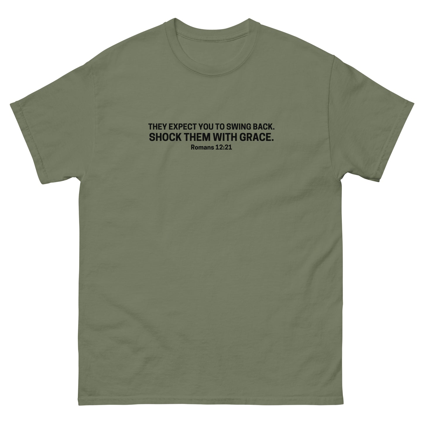 t-shirt with black text on the front that reads 'They expect you to swing back. Shock them with grace. Romans 12:21,' displayed flat on a white background. green