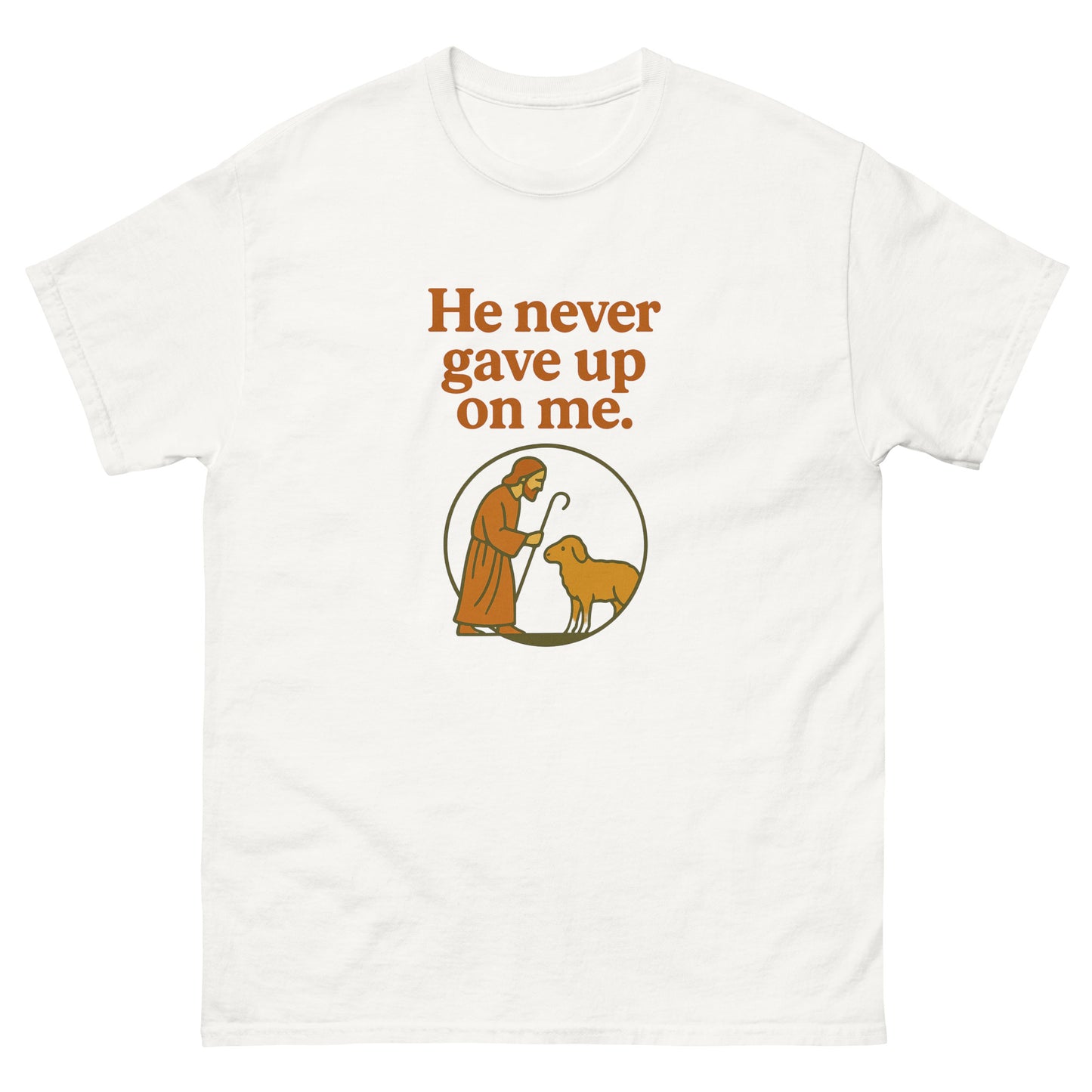 Christian T-shirt with the phrase 'He never gave up on me' above an illustration of Jesus as the shepherd standing with a sheep inside a circular frame. Front, White